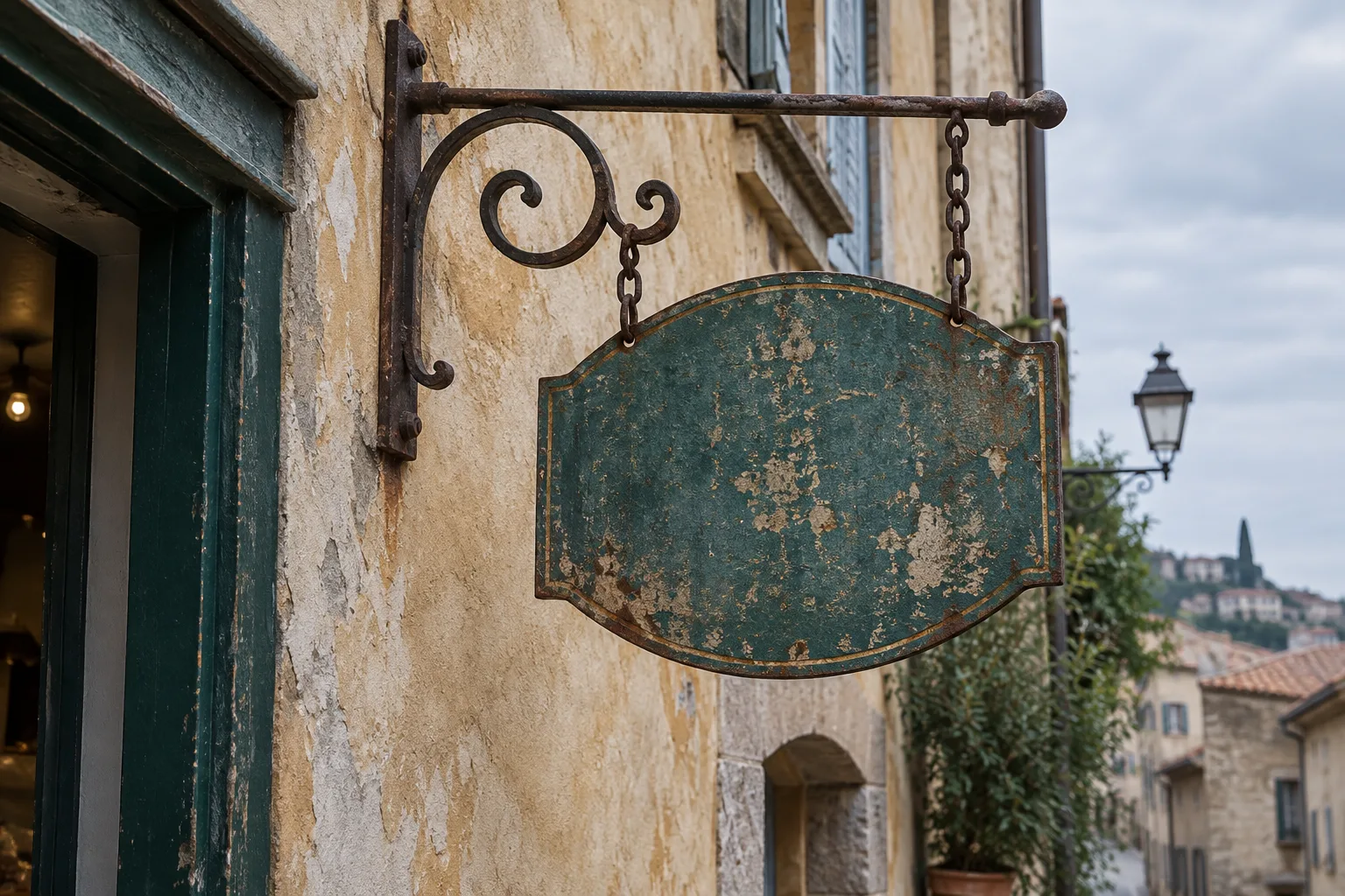 Une enseigne métallique usée est fixée à une façade ancienne, près d’une porte.